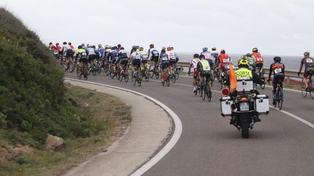 Peloton del GiroSardegna in azione su strada costiera
